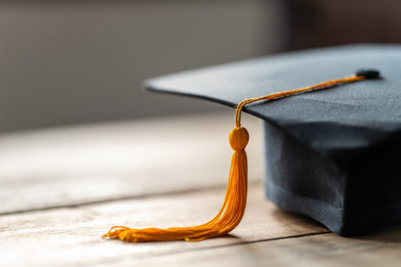 Close up photo of a Black graduation cap and yellow tassel