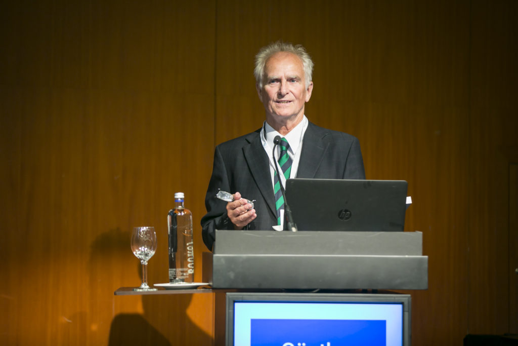 Man standing at a lectern giving a lecture