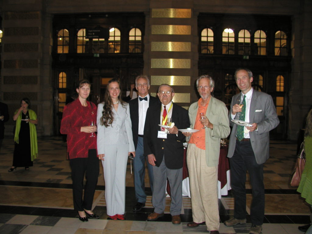 Six people standing, posing at a reception event