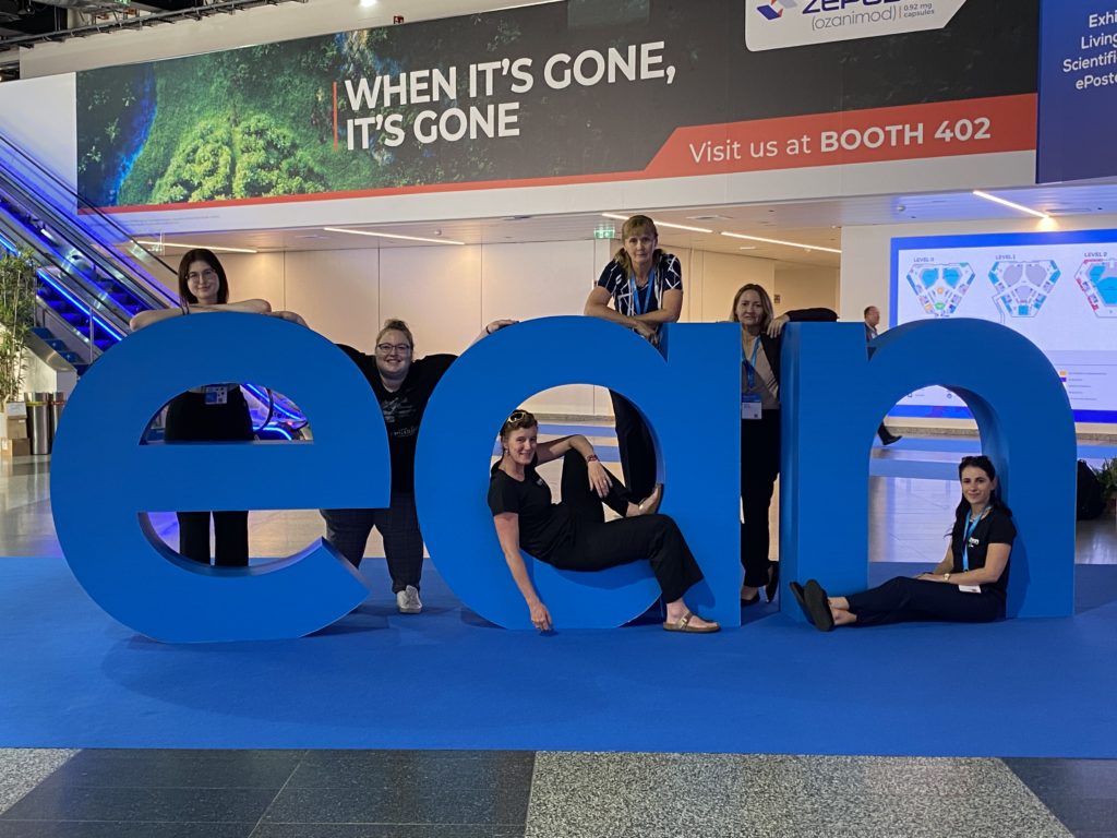 Six women, posing with some large cardboard letters that spell EAN