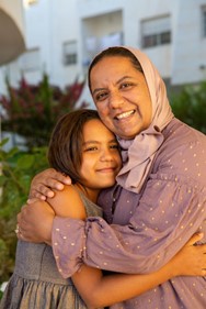 Woman and girl embracing and smiling