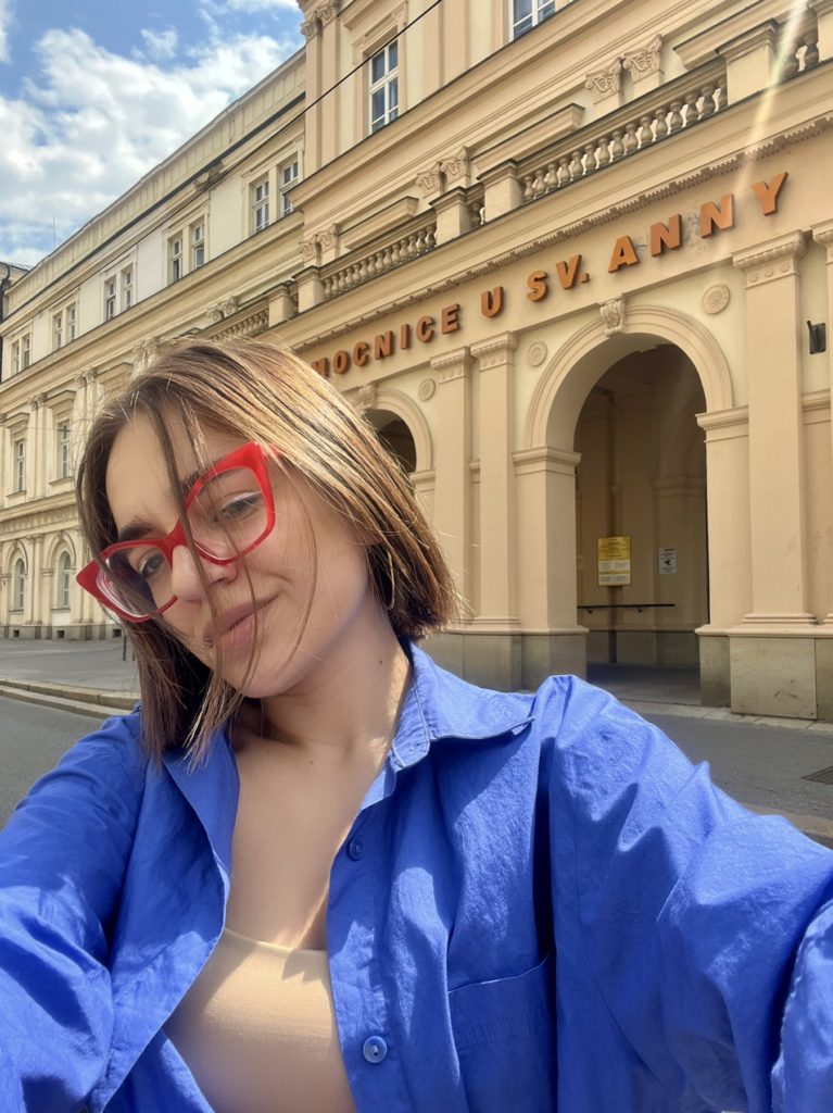 Selfie taken by woman with hospital building in background