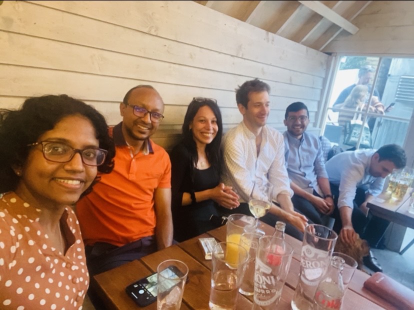 Group photo of six people seated in a bar