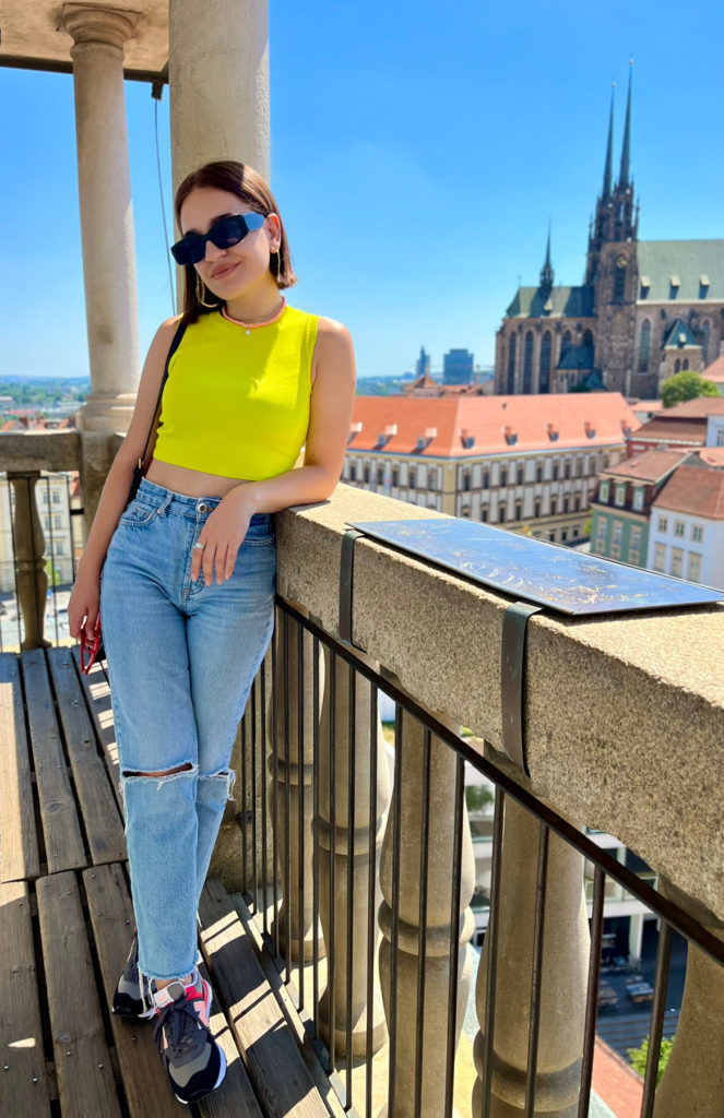 Woman leaning on a wall with city rooftops in background