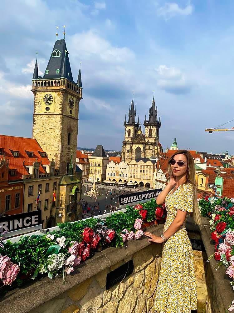 Photo of woman posing in front of old buildings in Prague
