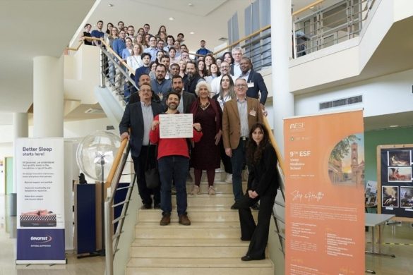 large group of course participants posing on internal stairway
