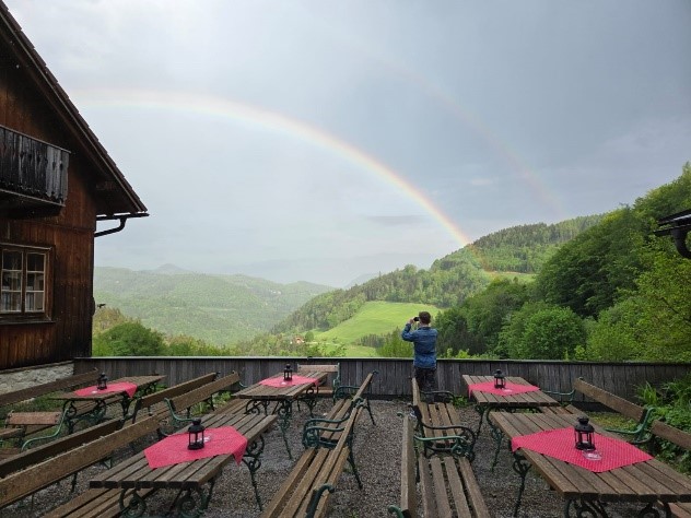 Wooden outdoor restaurant terrace with rainbow in background