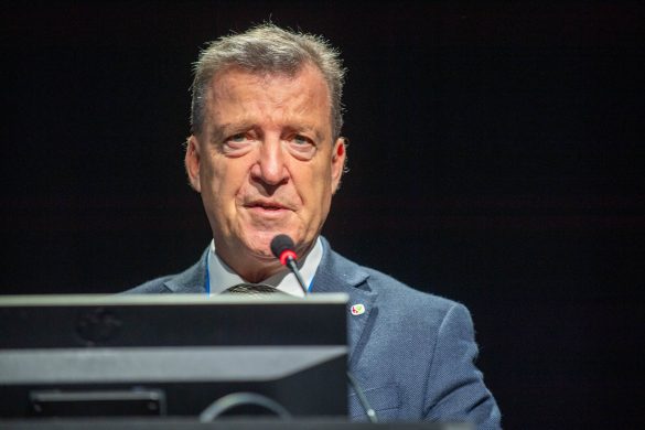 Head and shoulders of Claudio Bassetti standing on stage, with computer monitor in foreground